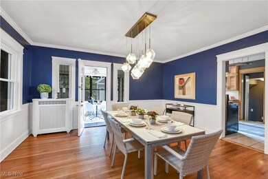 Dining area with ornamental molding, hardwood / wood-style flooring, a notable chandelier, and radiator heating unit
