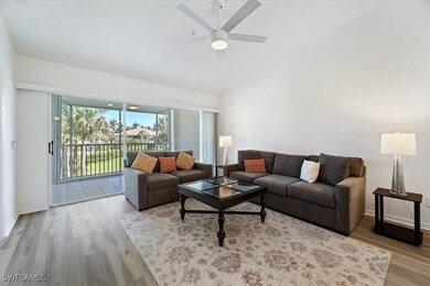 Living area with ceiling fan, wood finished floors, and high vaulted ceiling