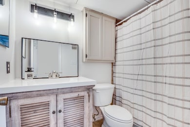 Full bathroom featuring upgraded lighting and vani