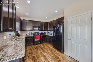 Kitchen with tile backsplash, light granite counte
