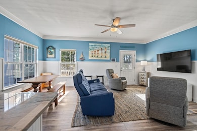 Living room featuring a ceiling fan, ornamental mo