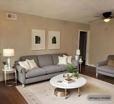 Living room with ceiling fan and dark wood-type fl