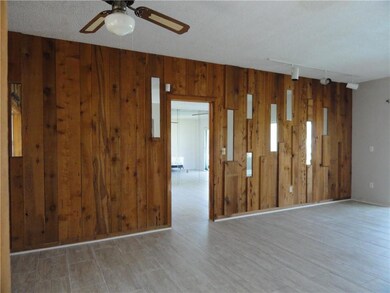 Living room and dining area. Tile flooring. Pecky