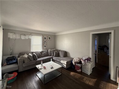 Living area featuring wood finished floors and a textured ceiling
