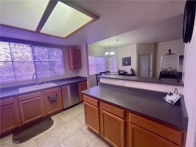 Kitchen featuring an inviting chandelier, dishwash