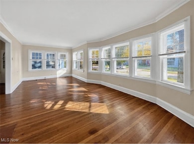 Unfurnished sunroom featuring ornamental molding and hardwood / wood-style floors
