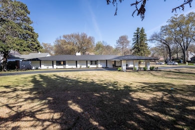 Ranch-style home featuring a chimney, a porch, and a front yard