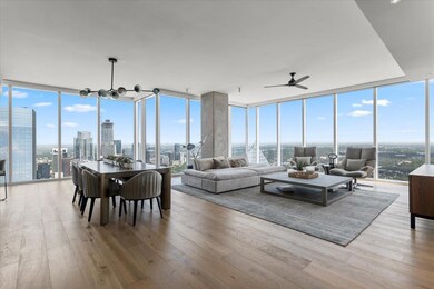 Living area with a wall of windows, a view of cit