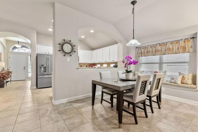 Dining area with arched walkways, lofted ceiling,