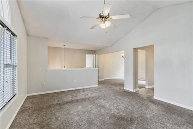 Empty room with ceiling fan, carpet flooring, vaul