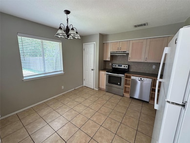 Kitchen featuring under cabinet range hood, stain