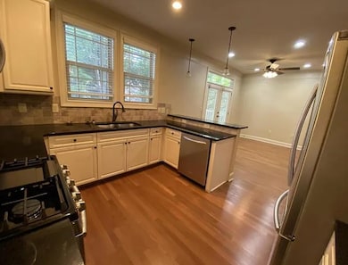 Kitchen with stainless steel appliances, white cabinetry, recessed lighting, ceiling fan, and pendant lighting