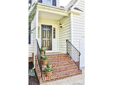 Covered, brick front stoop with freshly painted ra