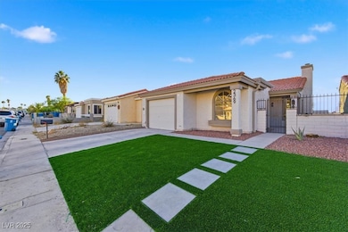 Mediterranean / spanish-style house featuring driveway, a tiled roof, a gate, an attached garage, and stucco siding