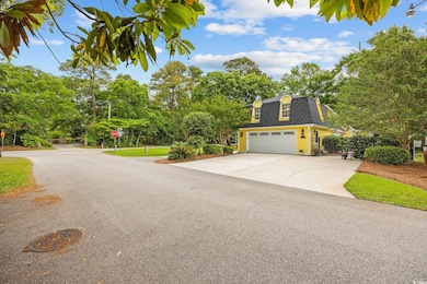 View of front of home featuring fence, a garage, c