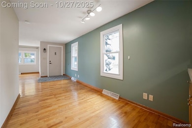 Foyer featuring light wood finished floors and baseboards