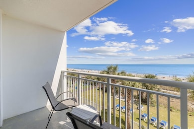 Balcony featuring view of water and beach