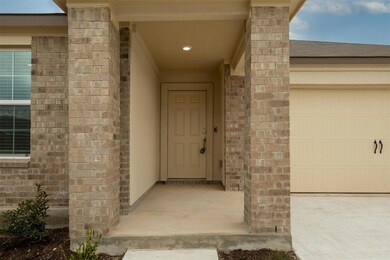 Entrance to property featuring brick siding and a garage