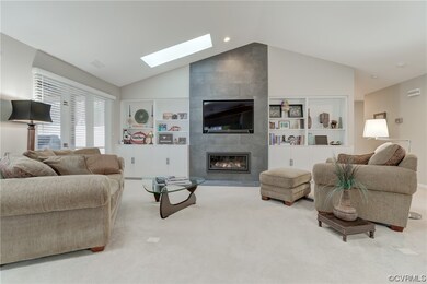 Living room featuring a tile fireplace, vaulted ce