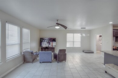 Tiled living room featuring ceiling fan with notab