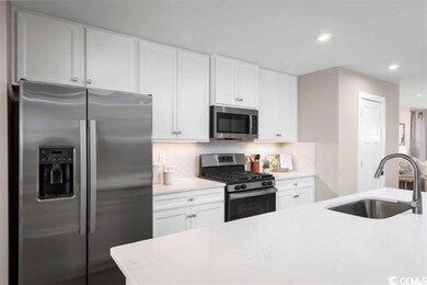 Kitchen featuring white cabinets, backsplash, appl