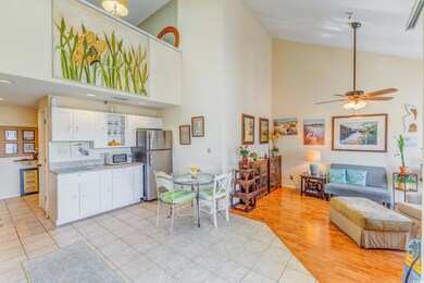 Kitchen featuring high vaulted ceiling, white cabinets, freestanding refrigerator, ceiling fan, and open floor plan
