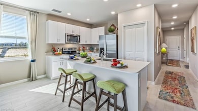 Kitchen with white cabinetry, sink, a breakfast ba