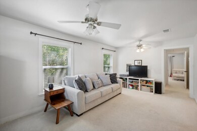 Carpeted living room featuring ceiling fan