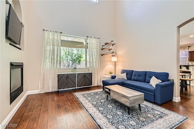 Living room with dark wood finished floors, a towe