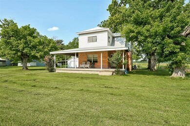 Rear view of property featuring a porch and a lawn