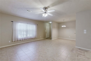Empty room with a textured ceiling, ceiling fan wi