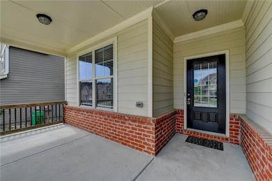 Doorway to property with covered porch and brick siding