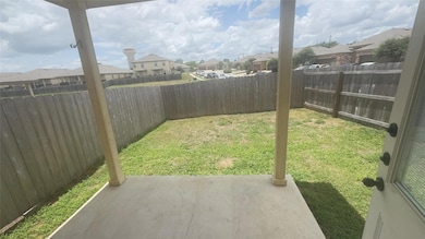 Fenced backyard with a residential view and a pat