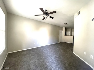 Spare room with ceiling fan, dark carpet, and base