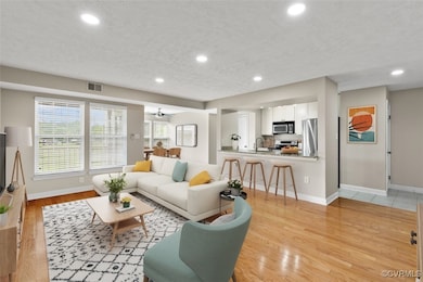 Living area with baseboards, recessed lighting, li
