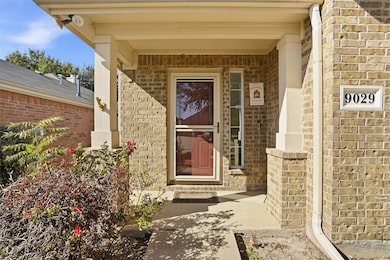 View of exterior entry with brick siding and covered porch
