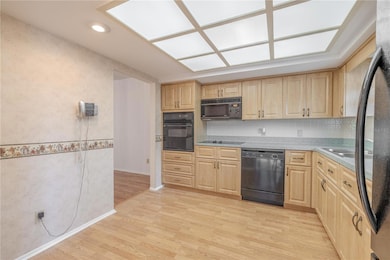 The kitchen features overhead lighting, a suite of appliances including a built in oven, electric cooktop, a microwave, dishwasher and refrigerator.