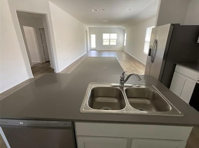 Kitchen with a sink, white cabinets, light wood-s