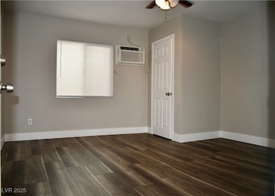 Studio featuring dark Vinyl finished floors, a wal