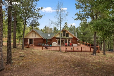 Rear view of property with log exterior, a deck, and roof with shingles