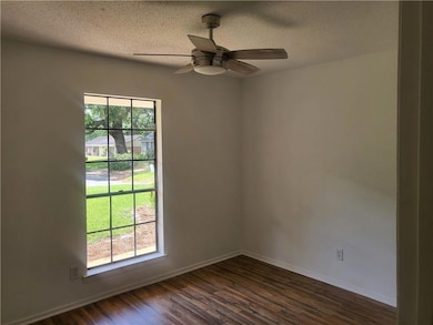 Master Bedroom with dark wood-style floors, baseboards, ceiling fan, and a textured ceiling
