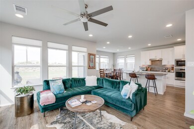 Living area with a ceiling fan, light wood-type f