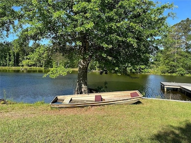 View of dock with a yard and a water view