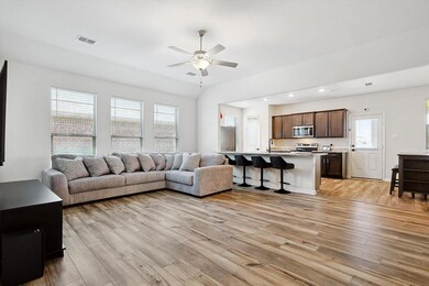 Living room featuring a healthy amount of sunlight, light hardwood / wood-style flooring, ceiling fan, and sink