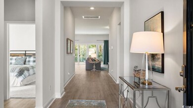 Corridor with baseboards, visible vents, and wood 