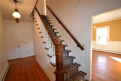 Wide front hallway with original hand milled stair