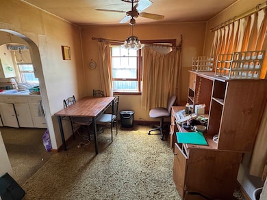 Office with arched walkways, carpet floors, and a ceiling fan
