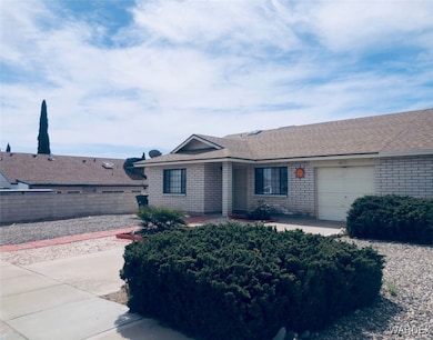 Single story home featuring a garage, roof with sh