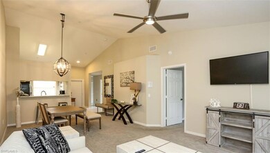 Carpeted living room featuring ceiling fan with no