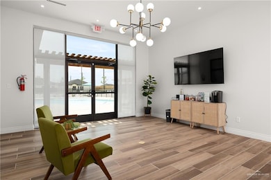 Living area with wood tiled floors, recessed lighting, and a chandelier